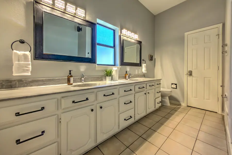 Bathroom with a long white double vanity and two framed mirrors