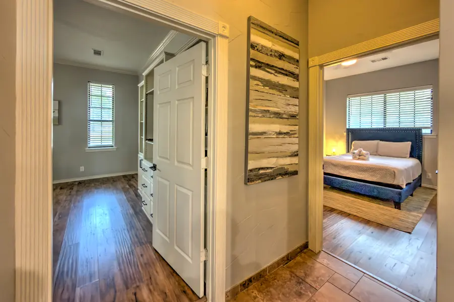 Hallway looking into a bedroom with a blue upholstered bed