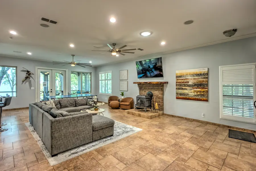 Living room with sectional sofa, wood stove on a brick hearth and wall-mounted TV