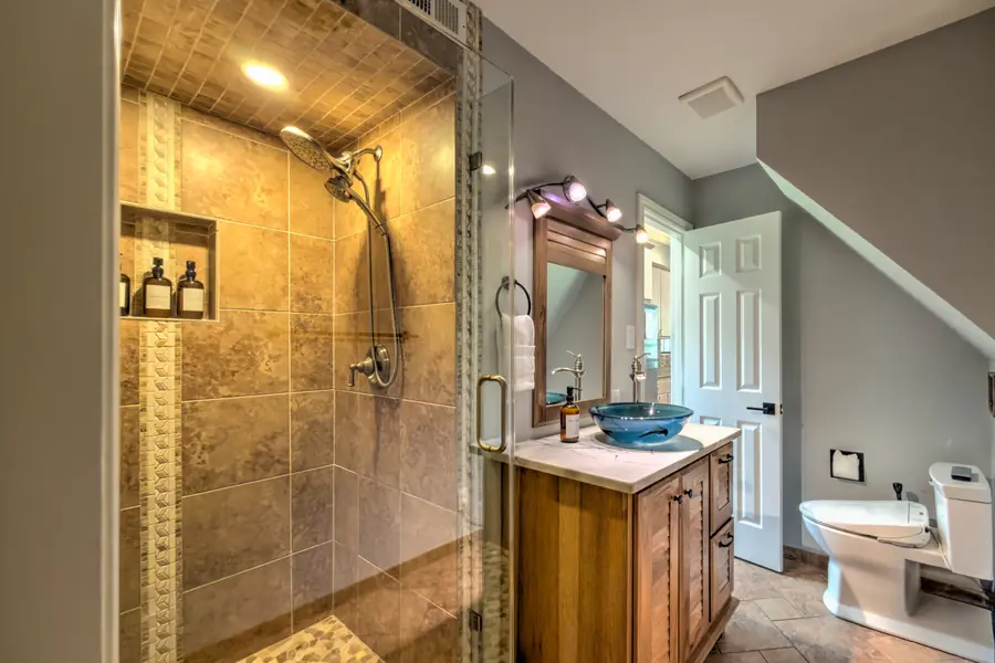 Bathroom with a tiled walk-in glass shower and a vessel sink
