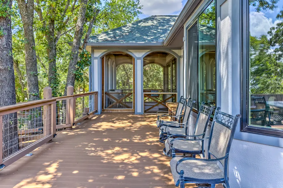 Side deck with a row of chairs leading to the screened porch